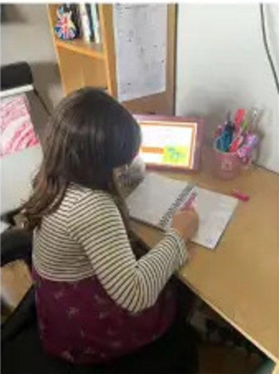 Child doing school work at a desk at home.