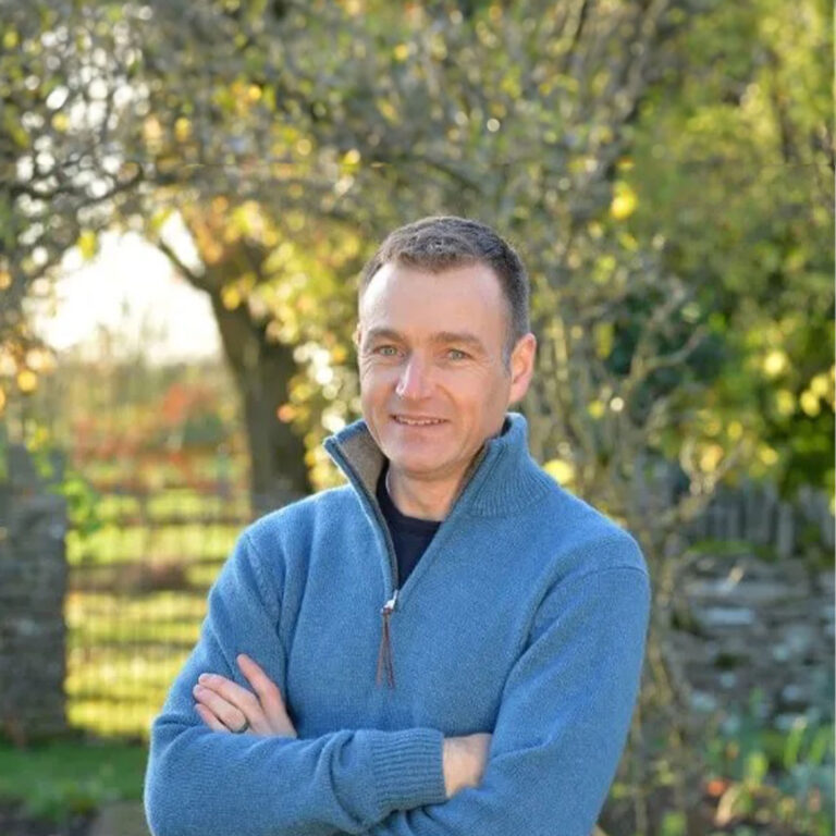 Chris Beardshaw stood outside in front of greenery