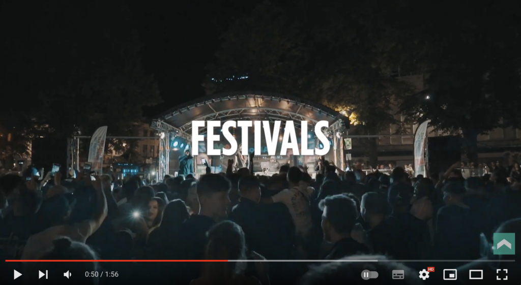 Screenshot of YouTube video displaying a stage with 'Festivals' overlaid on the video