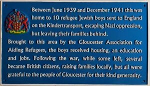 Blue plaque on 18 Alexandra Road honouring the 10 refugee Jewish boys who lived there. It reads: Between June 1939 and December 1941 this was home to 10 refugee Jewish boys sent to England on the Kindertransport, escaping Nazi oppression, but leaving their families behind. Brought to this area by Gloucester Association for Aiding Refugees, the boys received housing, an education and jobs. Following the war, while some left, several became British citizens, raising families locally, but all were grateful to the people of Gloucester for their kind generosity.