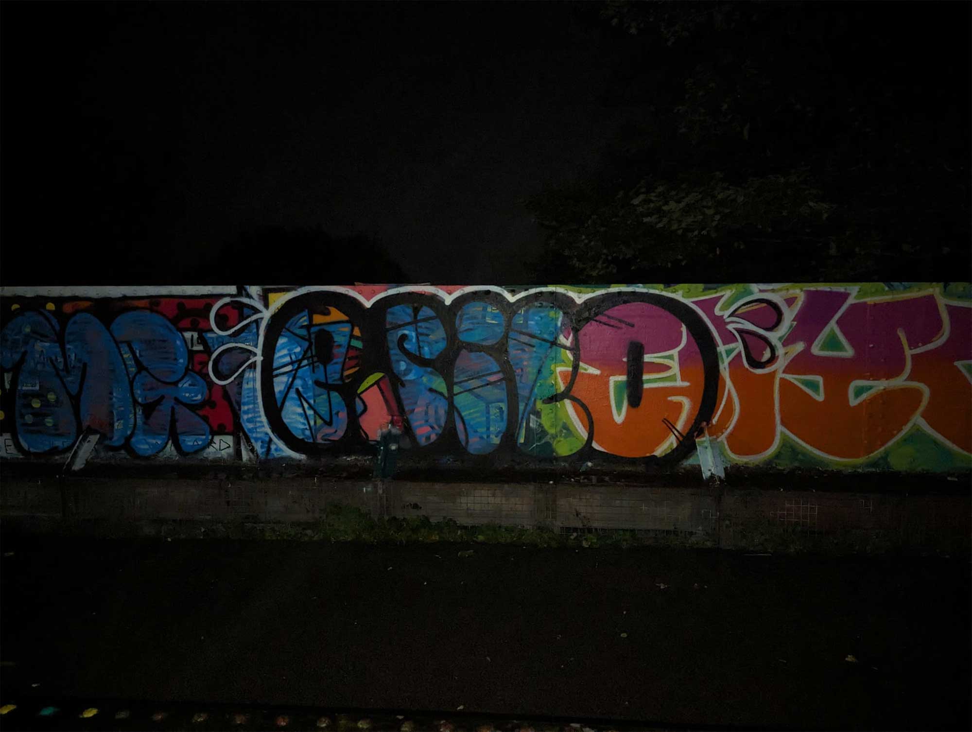 Graffiti on a wall at nigh-time.