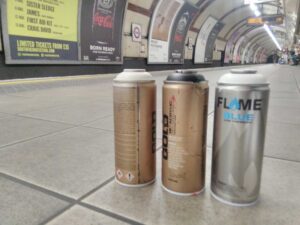 Spray cans sitting on the platform in a tube station.