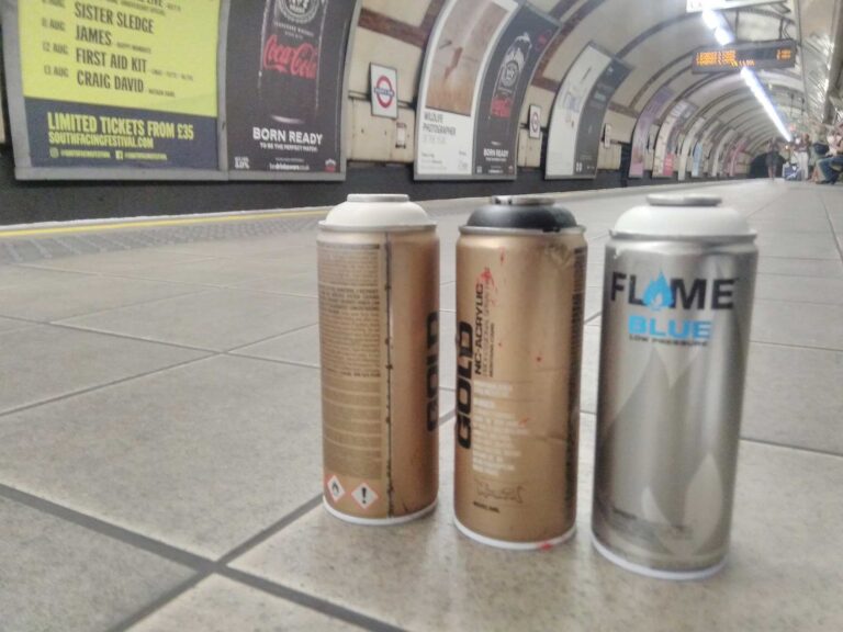 Spray cans sitting on the platform in a tube station.